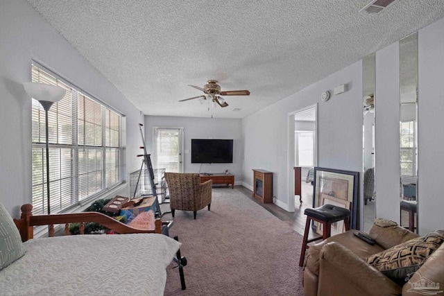 carpeted living room featuring a textured ceiling and ceiling fan