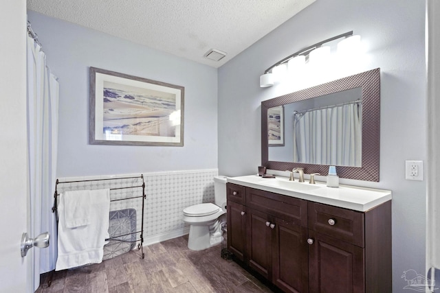 941 Summer Shade Ln, Cantonment, FL 32533 - full bathroom with wood finished floors, a wainscoted wall, vanity, toilet, and a textured ceiling