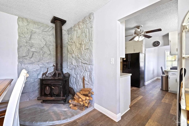 living room with ceiling fan, dark hardwood / wood-style flooring, and a textured ceiling