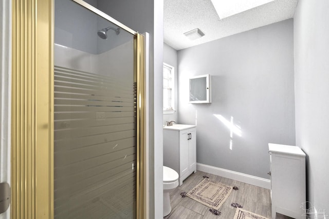 bathroom with a textured ceiling, toilet, vanity, a shower with shower door, and hardwood / wood-style flooring