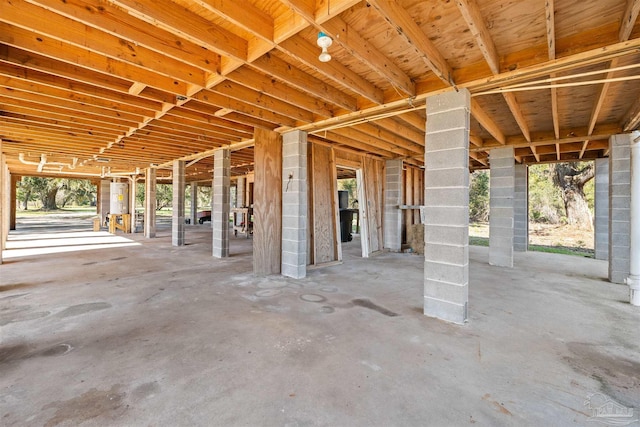 miscellaneous room featuring concrete floors, electric water heater, and plenty of natural light