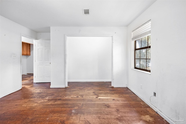 unfurnished room with dark wood-type flooring