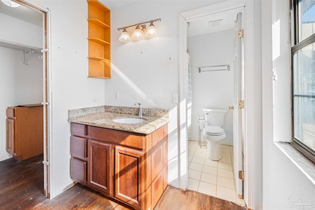 bathroom with hardwood / wood-style flooring, vanity, and toilet