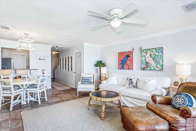 living area featuring visible vents, a ceiling fan, and ornamental molding