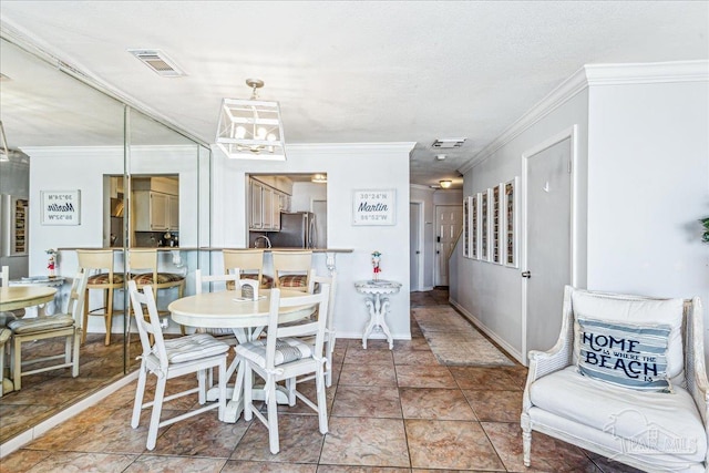 dining area featuring baseboards, an inviting chandelier, visible vents, and crown molding