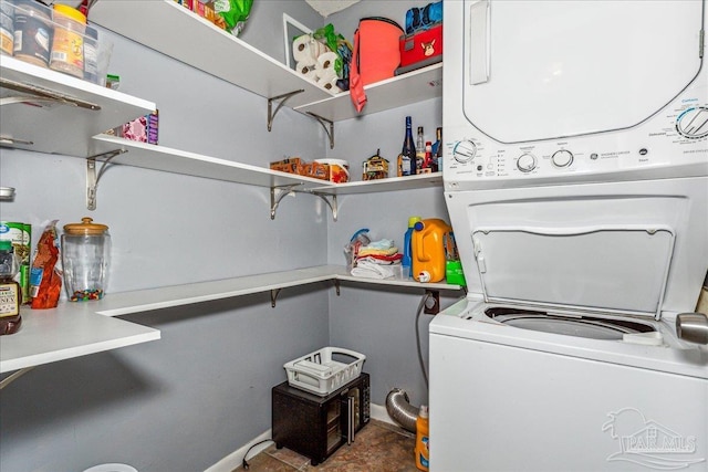 clothes washing area featuring stacked washer / drying machine and laundry area