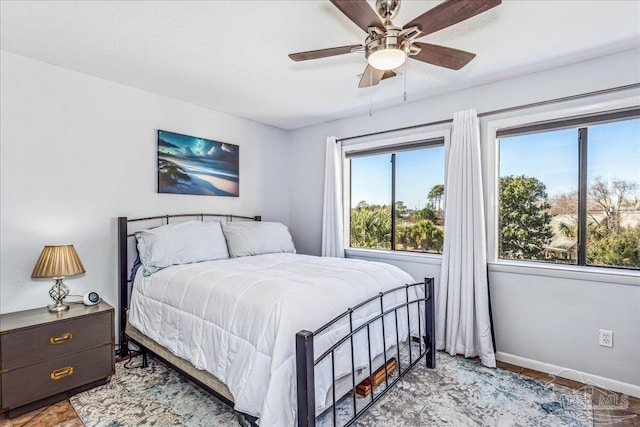 bedroom featuring ceiling fan and baseboards