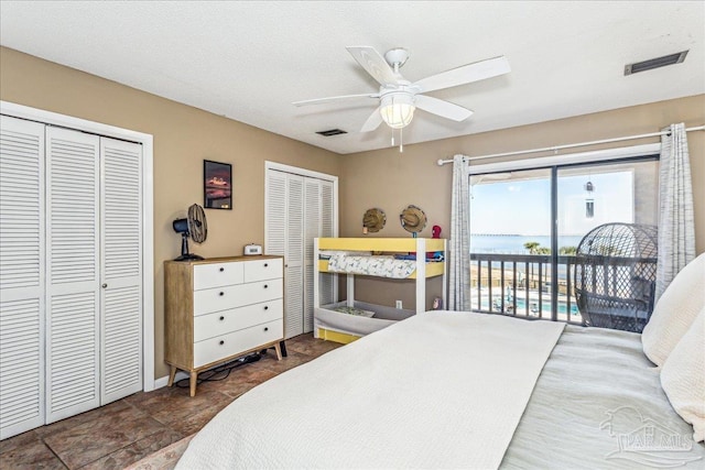 bedroom with ceiling fan, access to outside, two closets, and visible vents