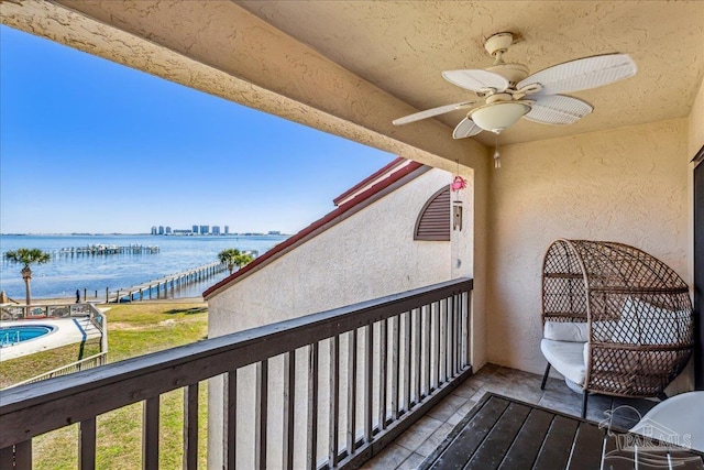 balcony featuring ceiling fan and a water view