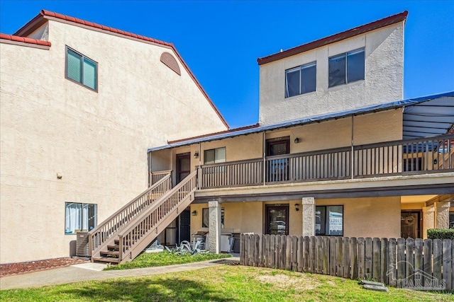 view of building exterior with stairway and fence