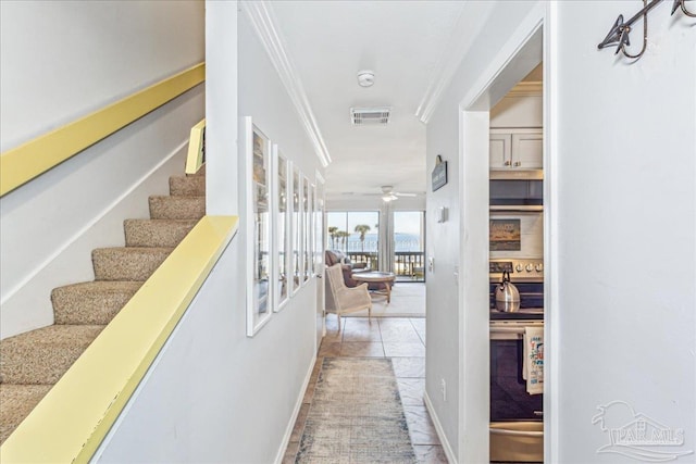 corridor featuring stairway, tile patterned flooring, visible vents, and crown molding