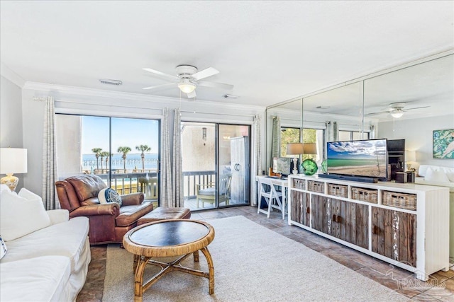 living area with a wealth of natural light, a ceiling fan, visible vents, and crown molding