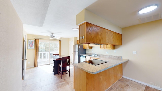 kitchen featuring sink, kitchen peninsula, ceiling fan, and appliances with stainless steel finishes