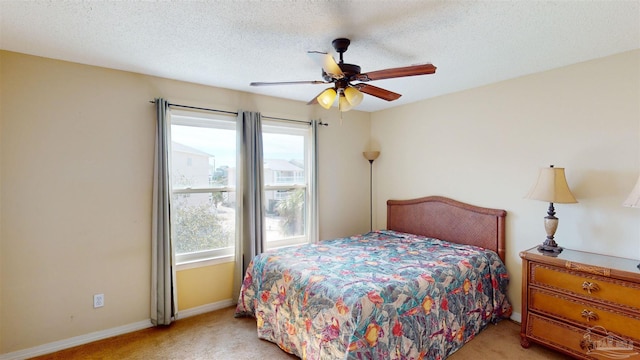 carpeted bedroom with ceiling fan and a textured ceiling