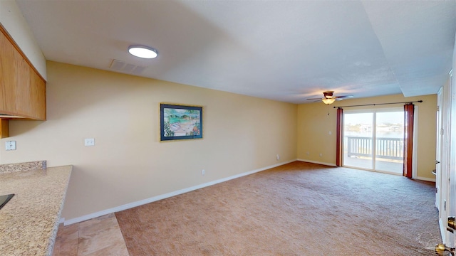 unfurnished living room with light colored carpet and ceiling fan