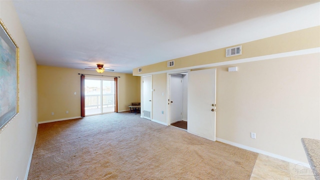 empty room with ceiling fan and light carpet