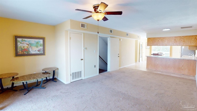 living room featuring light colored carpet and ceiling fan