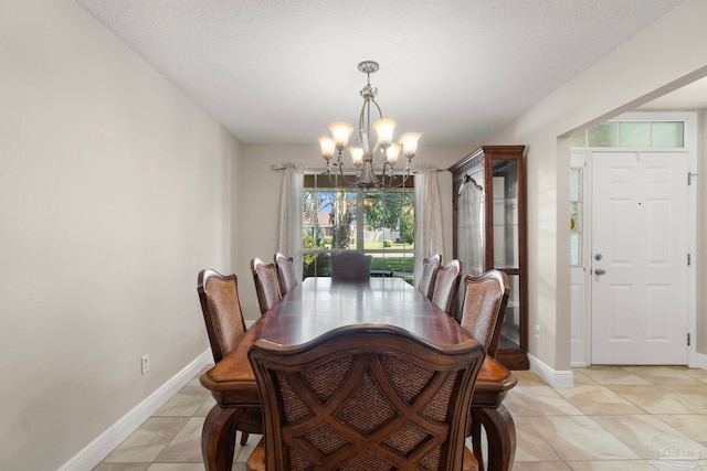 dining space with a notable chandelier, baseboards, and light tile patterned floors