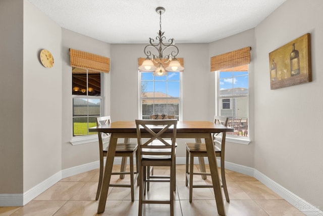 dining space with a chandelier, baseboards, and light tile patterned floors