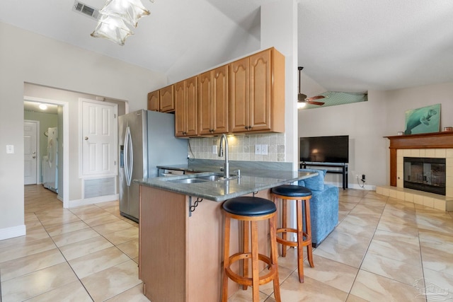 kitchen featuring tasteful backsplash, visible vents, vaulted ceiling, and dark stone countertops