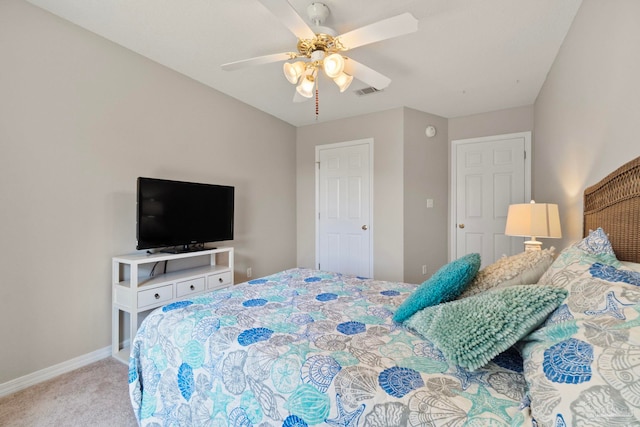 carpeted bedroom with visible vents, baseboards, and a ceiling fan