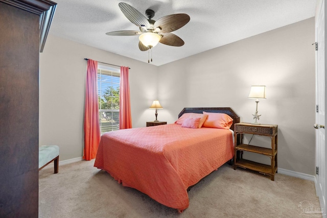 carpeted bedroom featuring ceiling fan, a textured ceiling, and baseboards