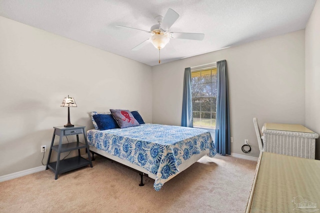 bedroom featuring light carpet, a textured ceiling, baseboards, and a ceiling fan