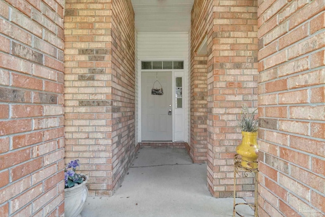 entrance to property featuring brick siding