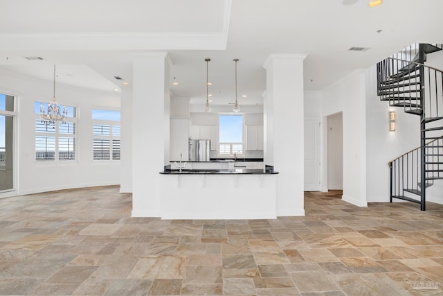 kitchen featuring white cabinets, decorative light fixtures, a chandelier, stainless steel refrigerator, and crown molding