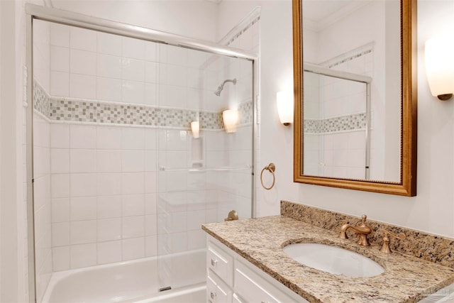 bathroom featuring ornamental molding, vanity, and combined bath / shower with glass door