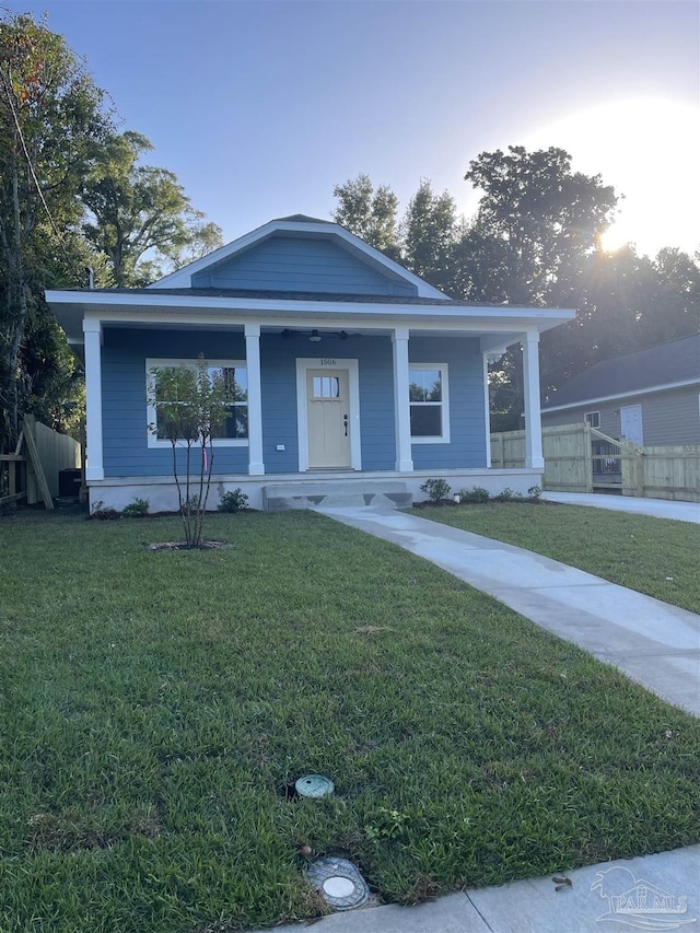 bungalow with covered porch and a front lawn