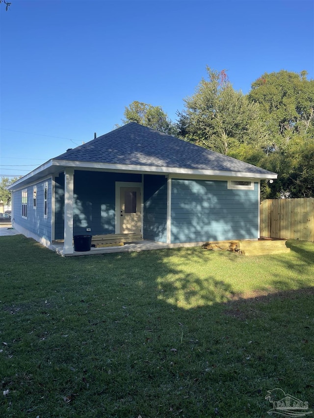 rear view of property featuring a yard and a patio area