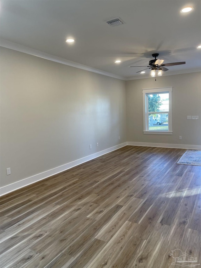 empty room featuring crown molding, ceiling fan, and dark hardwood / wood-style flooring