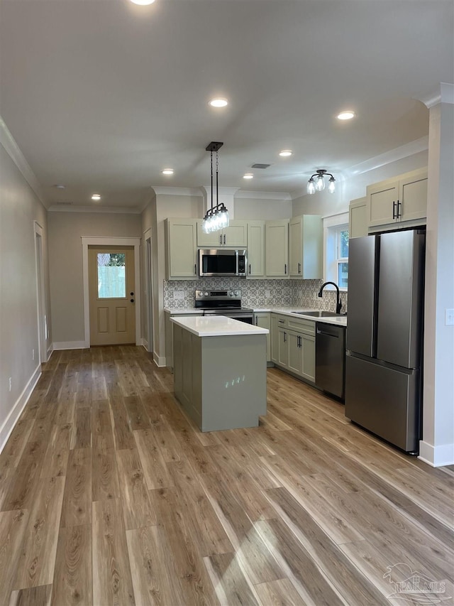 kitchen featuring sink, hanging light fixtures, backsplash, stainless steel appliances, and a kitchen island