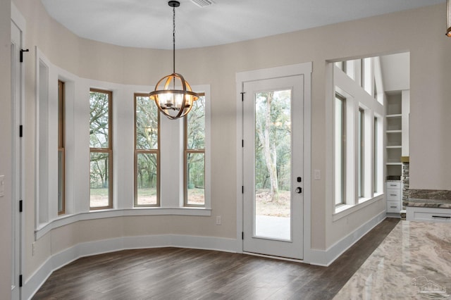 entryway featuring a notable chandelier, dark wood-style floors, baseboards, and a wealth of natural light