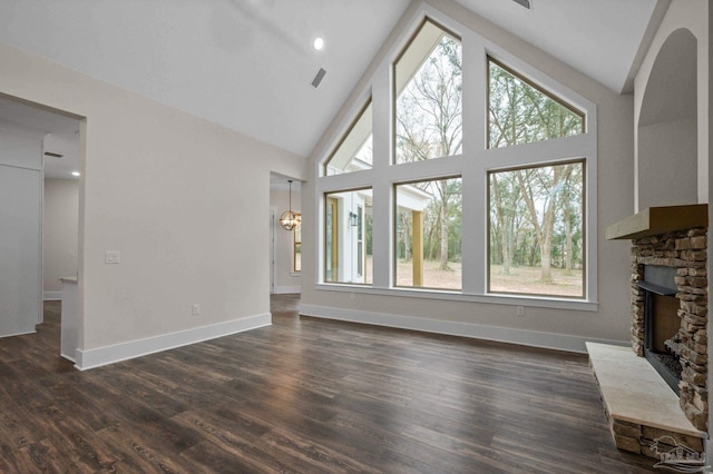 unfurnished living room featuring baseboards, a fireplace, dark wood-style flooring, and high vaulted ceiling