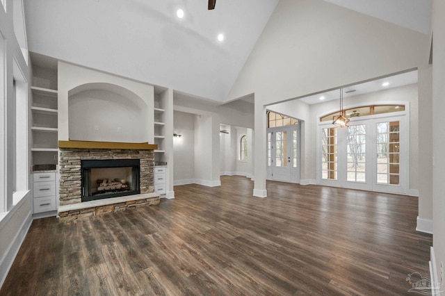 unfurnished living room featuring dark wood-type flooring, built in features, a fireplace, and baseboards