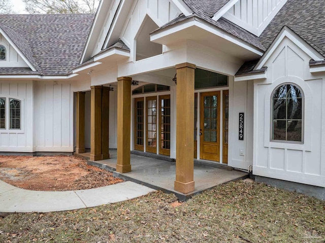 property entrance with a patio, board and batten siding, and roof with shingles