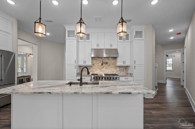 kitchen with visible vents, under cabinet range hood, high quality fridge, stove, and a sink