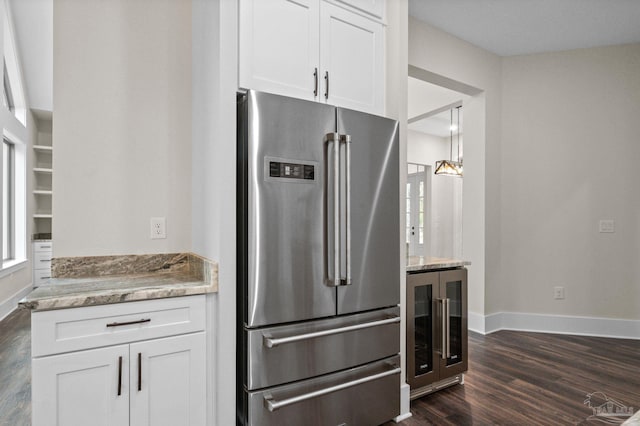 kitchen featuring white cabinetry, wine cooler, light stone countertops, and high end refrigerator