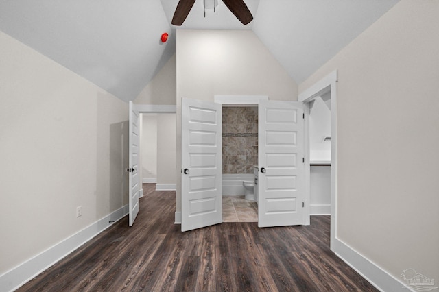 unfurnished bedroom with a ceiling fan, wood finished floors, baseboards, vaulted ceiling, and ensuite bathroom