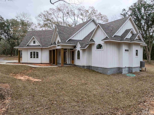 view of front of property featuring board and batten siding, central AC, and a shingled roof