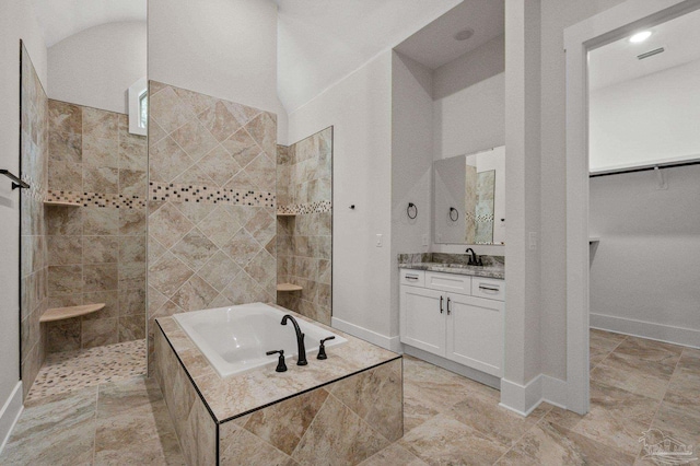 bathroom featuring visible vents, a garden tub, a walk in shower, baseboards, and vanity