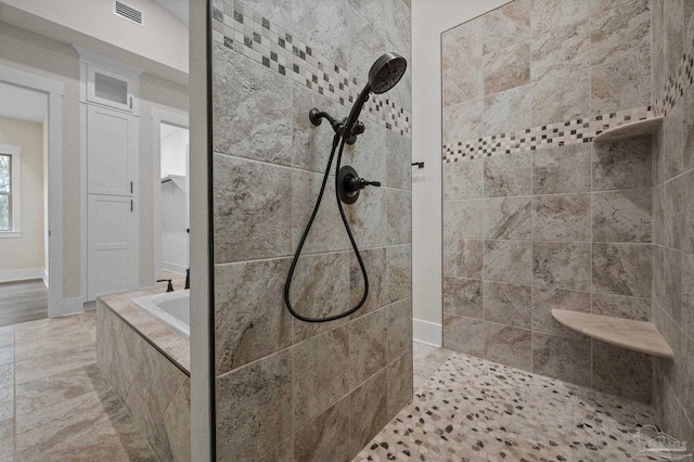 bathroom featuring visible vents, a bath, and a walk in shower