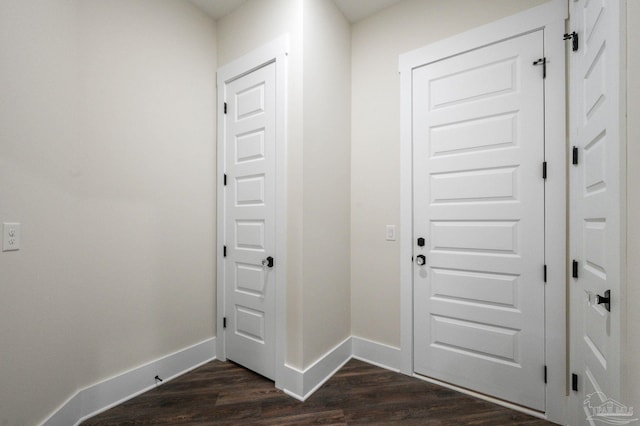 foyer entrance featuring baseboards and dark wood-style floors