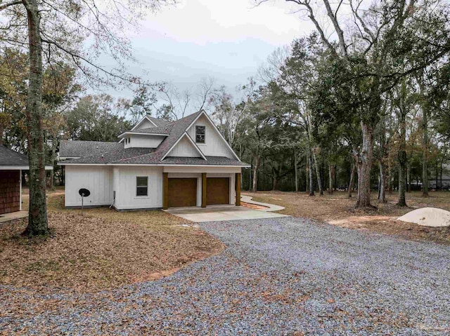 view of front facade featuring concrete driveway, a garage, and a shingled roof