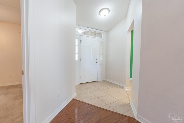 foyer featuring light tile patterned floors and baseboards