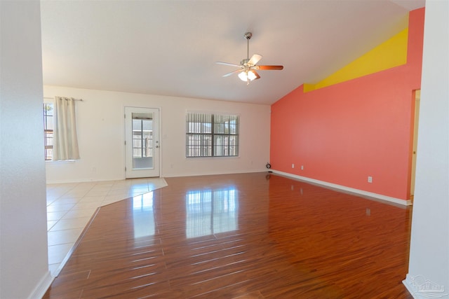 unfurnished room featuring baseboards, wood finished floors, ceiling fan, and vaulted ceiling