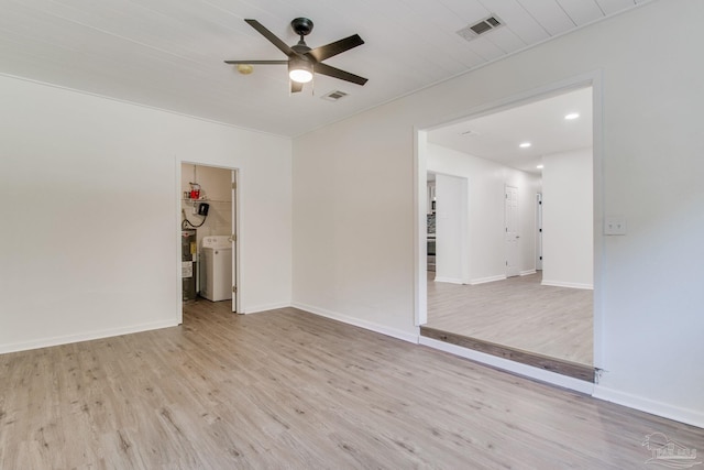 spare room with ceiling fan, light hardwood / wood-style floors, and washer / dryer