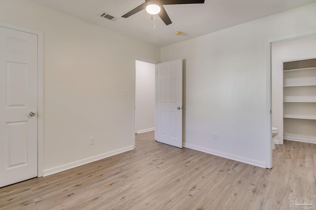 unfurnished bedroom with connected bathroom, ceiling fan, and light wood-type flooring